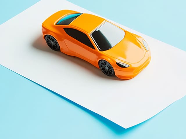 書類の上に乗っているおもちゃの車の画像