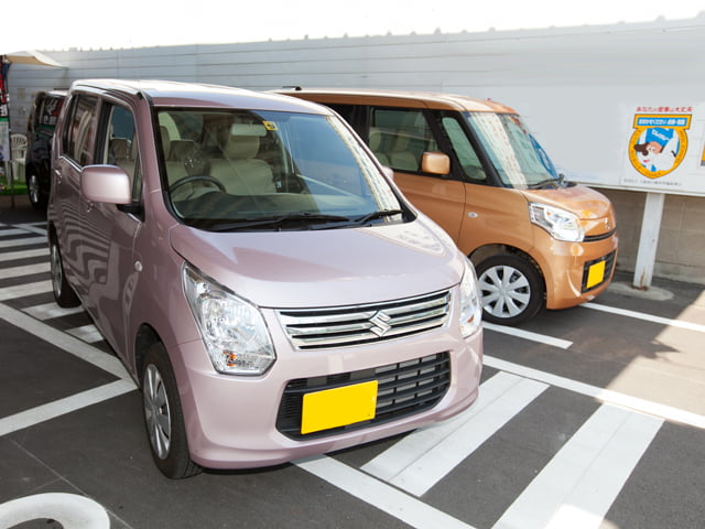 発進しようとしているピンクの軽自動車